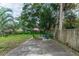 Private, fenced backyard with patio area, lush greenery, and mature trees at 331 Sheldon St, New Smyrna Beach, FL 32168