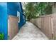 Long concrete driveway leads to a wooden gate and the backyard of the blue home at 331 Sheldon St, New Smyrna Beach, FL 32168