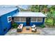 Charming blue home with metal roof, a wooden deck, and outdoor seating area at 331 Sheldon St, New Smyrna Beach, FL 32168