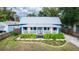 Blue cottage with a metal roof, white accents, and lush landscaping at 331 Sheldon St, New Smyrna Beach, FL 32168