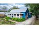 Charming blue house with white trim, a metal roof, and a landscaped yard at 331 Sheldon St, New Smyrna Beach, FL 32168