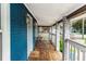 Covered front porch with white railing, blue painted brick, and wood-look flooring at 331 Sheldon St, New Smyrna Beach, FL 32168