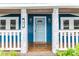 Inviting front porch with blue brick, white columns, and a light blue door at 331 Sheldon St, New Smyrna Beach, FL 32168
