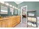 Bright bathroom with double sinks, granite countertop, and access to bedroom at 3782 Pine Cone Ln, Ormond Beach, FL 32174
