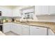 Bright kitchen features granite countertops, white cabinets, and stainless steel appliances at 3782 Pine Cone Ln, Ormond Beach, FL 32174