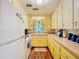 Bright kitchen with yellow cabinets, laminate countertops, and wood flooring at 410 N Thorpe Ave, Orange City, FL 32763