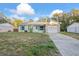 Front view of a single story house with a white garage door and teal shutters at 711 S Pearl St, Deland, FL 32720