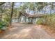 Charming blue home nestled among trees with a brick driveway at 855 E Church St, Deland, FL 32724