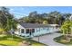 Front view of a teal house with a driveway and landscaping at 1146 Riverside Dr, Daytona Beach, FL 32117