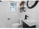 Modern bathroom with white shiplap walls, floating vanity, and black fixtures at 3603 Surfside Ter, Port Orange, FL 32127