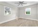 Bright bedroom with wood-look floors, ceiling fan, and window blinds at 3603 Surfside Ter, Port Orange, FL 32127
