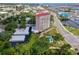 High-angle aerial view of The Landmark building with a pool, parking, and surrounding trees at 404 S Beach St # 010 101, Daytona Beach, FL 32114