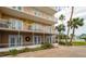 Balcony with decorative sunflowers, white railing, screened enclosure, and landscaping at 404 S Beach St # 010 101, Daytona Beach, FL 32114