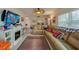 Living room with a ceiling fan, sectional couch, fireplace, and holiday decor at 404 S Beach St # 010 101, Daytona Beach, FL 32114