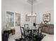 Bright dining room features a glass table, four chairs, and a modern chandelier at 437 Harbour Town Ln, Ormond Beach, FL 32174