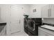 Modern laundry room with washer, dryer, and ample counter space at 437 Harbour Town Ln, Ormond Beach, FL 32174
