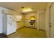 Galley kitchen with white cabinets and appliances at 451 Arthur Ave, Daytona Beach, FL 32114