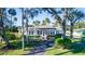 Quaint light blue house with a well-manicured lawn and mature trees at 5178 Riverside Dr, Port Orange, FL 32127