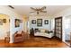 Living room with hardwood floors, curved sofa, and access to the sunroom at 5178 Riverside Dr, Port Orange, FL 32127
