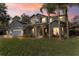 Two-story house with a three-car garage, stone accents, and a manicured lawn at dusk at 973 Bearded Oaks Ter, Longwood, FL 32779