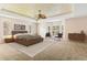 Main bedroom with carpeted floors, tray ceiling, and staged furniture at 973 Bearded Oaks Ter, Longwood, FL 32779