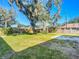 Large backyard with grassy area and large shade tree at 2129 Lime Tree Dr, Edgewater, FL 32141