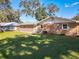 Tan brick ranch home with a brown door and landscaped yard at 2129 Lime Tree Dr, Edgewater, FL 32141