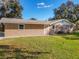 Tan brick ranch home with a neatly landscaped lawn at 2129 Lime Tree Dr, Edgewater, FL 32141