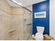 Bathroom with walk-in shower and blue accent wall at 2300 N Atlantic Ave # 1701, Daytona Beach, FL 32118