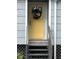 Yellow front door with wreath, gray siding, and steps at 2329 River Ridge Rd # 13, Deland, FL 32720