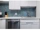Clean kitchen with white cabinets, stainless steel dishwasher, and blue tile backsplash at 2700 Ocean Shore Blvd # 317, Ormond Beach, FL 32176