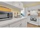 White kitchen cabinets and countertops, stainless steel appliances at 2800 N Atlantic Ave # 212, Daytona Beach, FL 32118