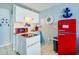 Compact kitchen with red refrigerator and nautical accents at 3501 S Atlantic Ave # 2030, Daytona Beach, FL 32118