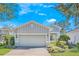 Single-story home with light gray siding, a two-car garage, and a nicely landscaped front yard at 430 Cypress Hills Way, Deland, FL 32724