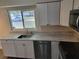 Modern kitchen with white cabinets, stainless steel appliances, and gray countertops at 525 E Roberts St, Orange City, FL 32763