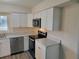 Modern kitchen with white cabinets, stainless steel appliances, and gray countertops at 525 E Roberts St, Orange City, FL 32763