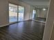 Living room with gray vinyl flooring and sliding glass doors leading to a patio at 525 E Roberts St, Orange City, FL 32763