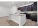 Modern kitchen with island, dark cabinets, granite counters, and stainless steel appliances at 553 Coronado Cove Rd, New Smyrna Beach, FL 32168