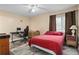 Cozy bedroom with a red bedspread, a workspace, and window coverings at 633 S Palmetto Ave # 1010, Daytona Beach, FL 32114
