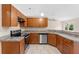 Modern kitchen featuring wood cabinets, stainless steel appliances, and granite countertops at 691 N Firwood Dr, Deltona, FL 32725