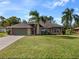 Brick house with a two-car garage and palm trees at 1448 Galena Ter, Deltona, FL 32725