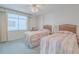Guest bedroom with two twin beds and light carpet at 3 Oceans West Blvd # 4A5, Daytona Beach Shores, FL 32118