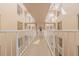 Bright hallway with white railings and light beige walls at 3 Oceans West Blvd # 4A5, Daytona Beach Shores, FL 32118
