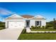 One-story house with light blue exterior, gray shutters, and a two-car garage at 1235 Tank Trl, Haines City, FL 33844
