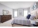 Spacious bedroom with striped bedding and large windows at 1235 Tank Trl, Haines City, FL 33844