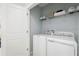 Well-lit laundry room with washer, dryer, and overhead shelving at 1235 Tank Trl, Haines City, FL 33844