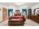 Main bedroom with a four-poster bed and built-in shelving at 4920 Sw 78Th Ave, Bushnell, FL 33513