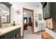 Elegant bathroom with dark green vanity and large mirror at 4920 Sw 78Th Ave, Bushnell, FL 33513