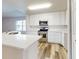 Modern kitchen with white cabinets, island, and stainless steel appliances at 107 Littleton Cir, Deland, FL 32724