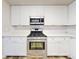 Modern kitchen with white cabinets and stainless steel appliances at 107 Littleton Cir, Deland, FL 32724